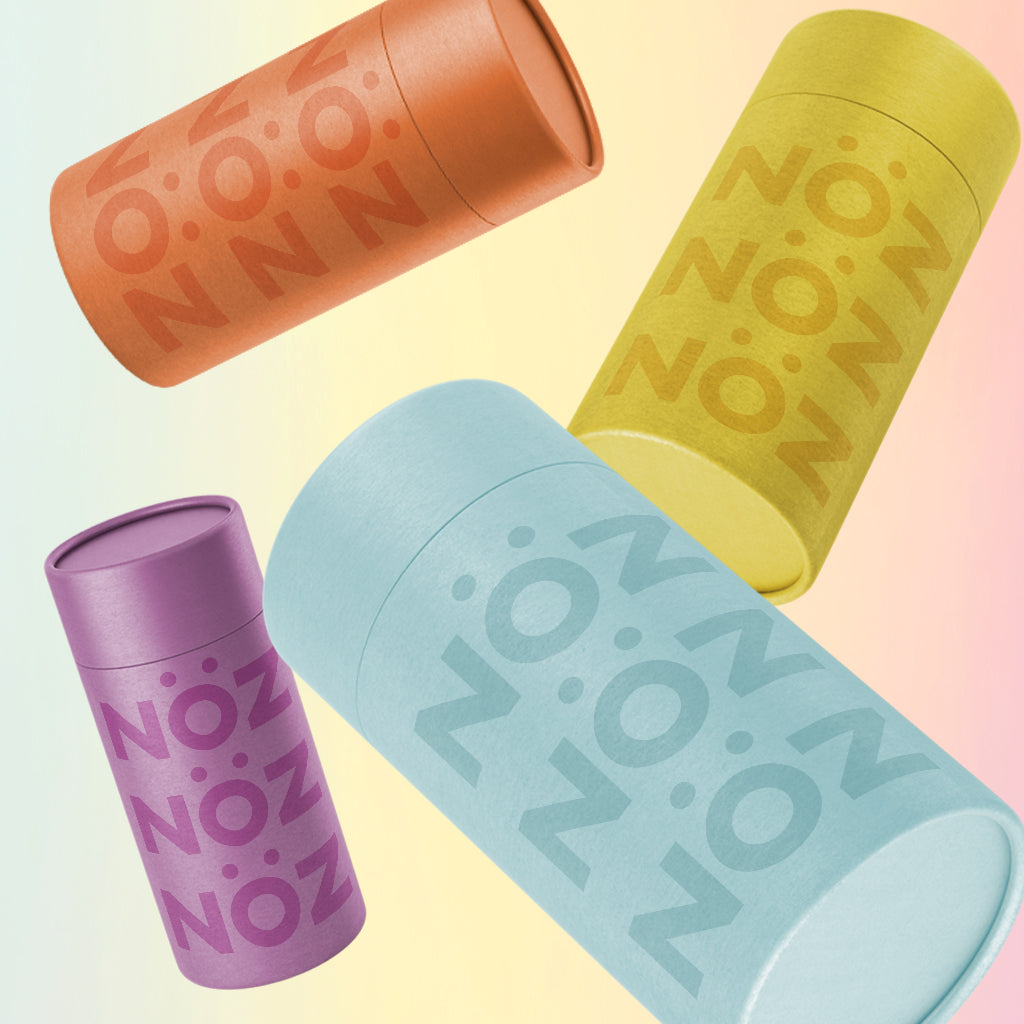 Nöz signature sunscreen in Yellowstone Yellow, Baltic Sea Blue, Okavango Orange, and Provence Purple floating on a neutral background.